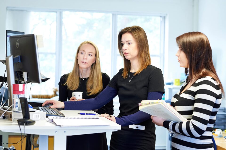 a photo of team members Kristie, Mel and Jenny working at laptop on a clients website