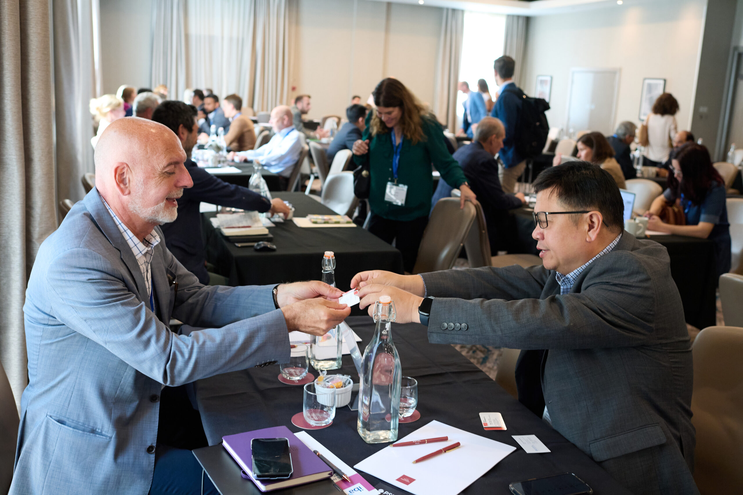 two men exchanging business cards, holding the business cards with both hands, as is custom in chinese culture