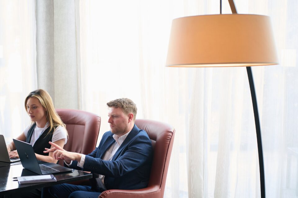 a image of team members jake and mel working at a desk